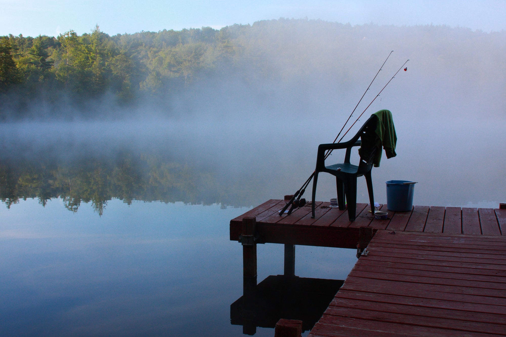 Dock fishing with a foggy lake background.
